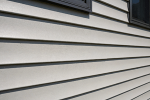 Close-up of clean horizontal vinyl siding panels on a modern suburban home exterior in daylight