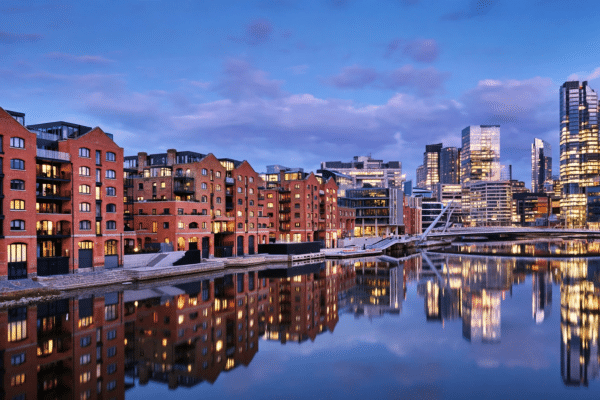 Modern UK city skyline at dusk with riverside apartment buildings, representing the best UK cities for property investment in 2026