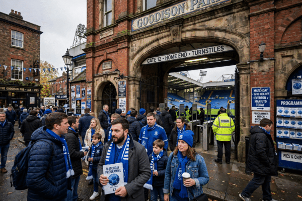 Supporters arriving at a historic English football stadium on matchday, blue seats visible inside