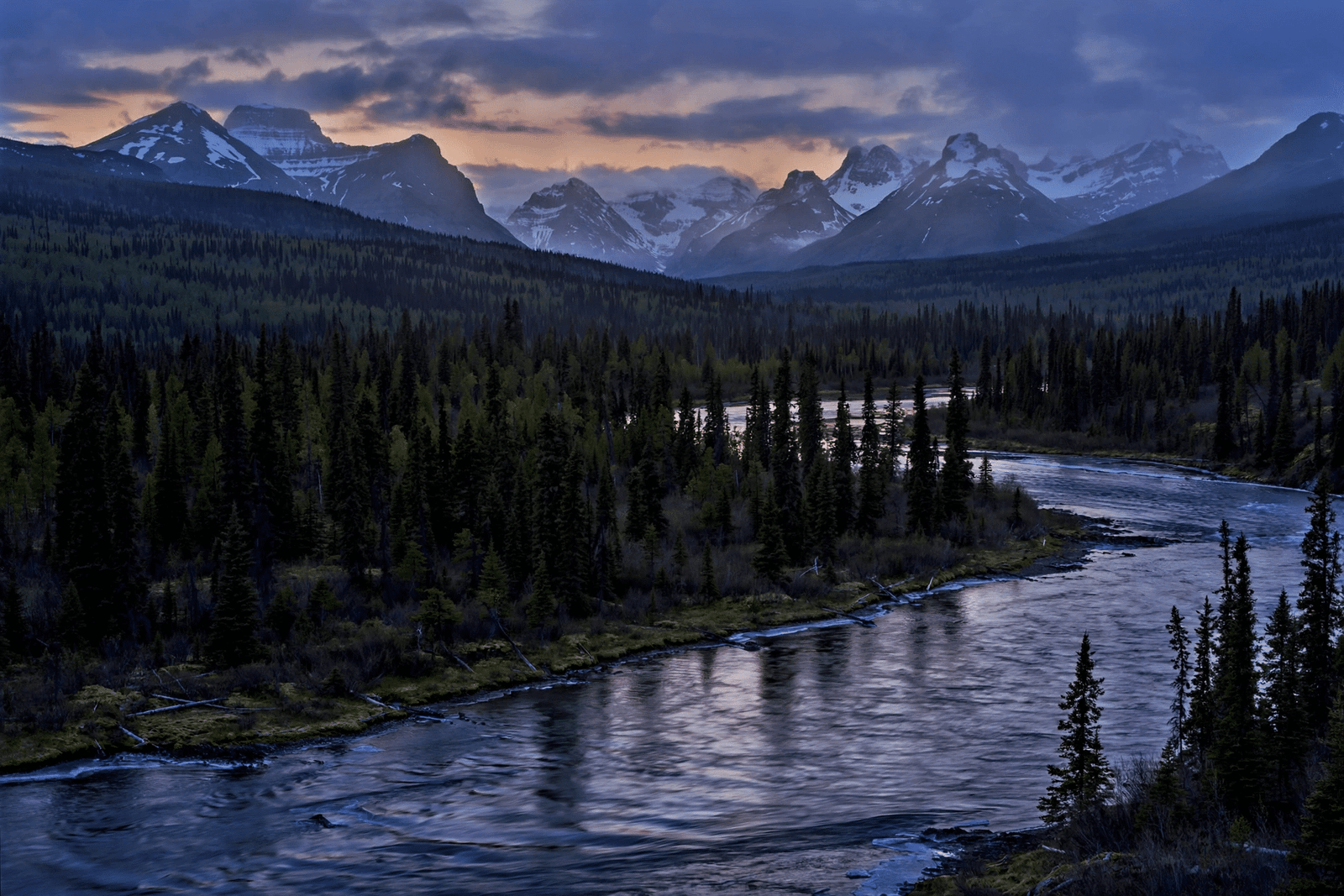 Vast Yukon wilderness landscape with a river and spruce forest at dusk in northern Canada
